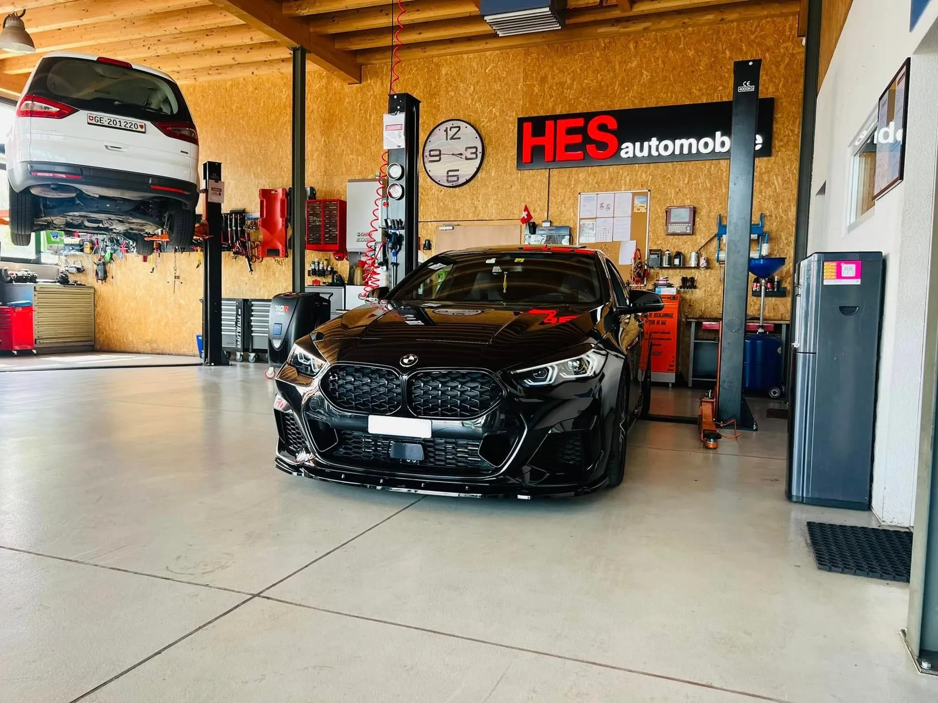 Réparation d’une voiture sur pont élévateur dans l’atelier HES Automobile à Meyrin
